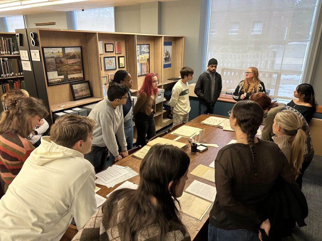 Students looking at documents around a table. 